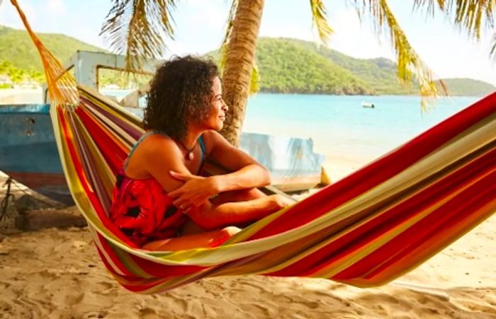 A woman relaxing in a hammock, taking in the beauty of a Caribbean beach during a shore excursion.