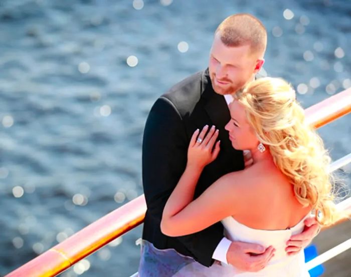 Newlyweds embrace as they gaze out at the ocean from a cruise ship.