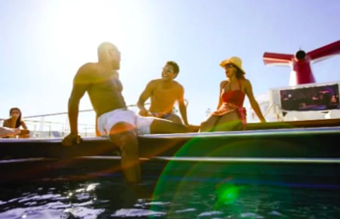 Three friends chatting in their swimsuits beside the pool on a Dinogo ship