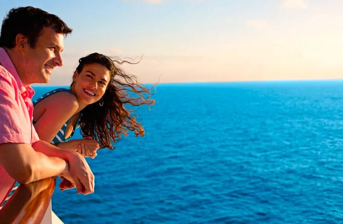 A woman gazes at a man who is lost in thought, looking out at the ocean from the deck of a cruise ship.