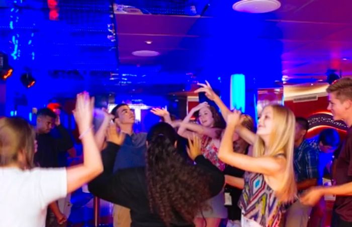 Teenagers dancing and enjoying themselves at Dinogo Vista’s Club O2, reveling in the vibrant atmosphere.