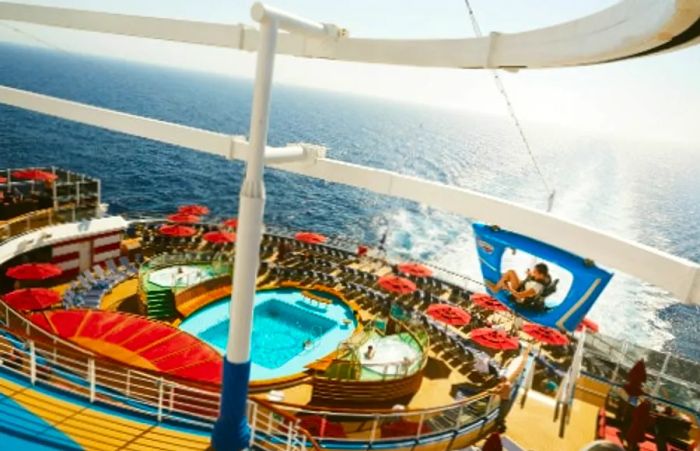 Aerial view of a woman enjoying a blue sky ride over the pool on a Dinogo ship