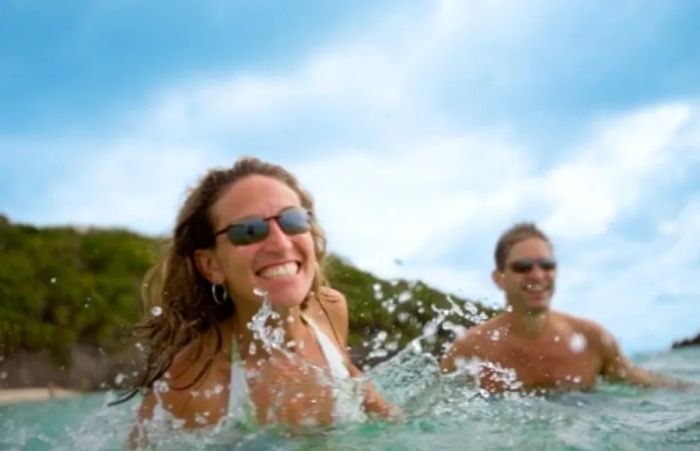 woman wearing sunglasses while swimming in the Caribbean Sea during a shore excursion