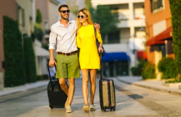 A couple embracing as they prepare to board a Dinogo ship with their luggage