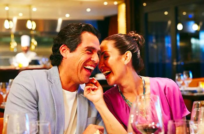 A couple shares laughter while enjoying a romantic dinner at Fahrenheit 555 Steakhouse.