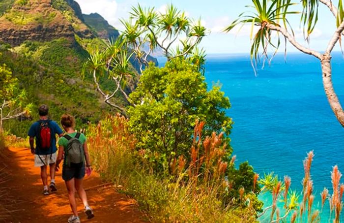 A man and woman hike along a trail in Kauai, Hawaii