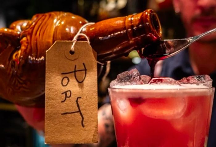 a glass of port wine being poured into a Portuguese cocktail