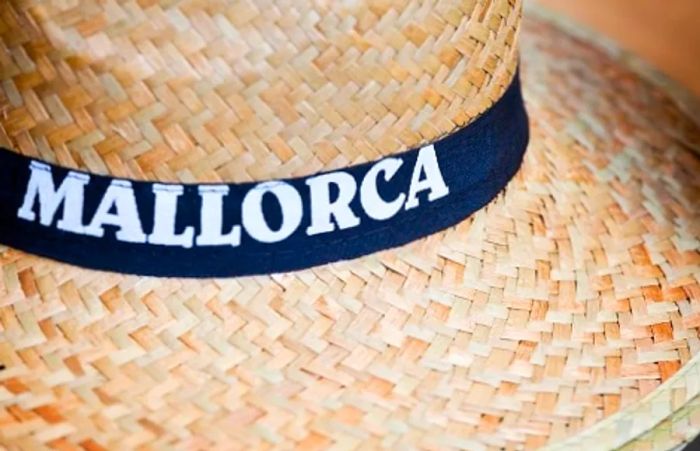 a straw hat featuring a black band that says Mallorca on it