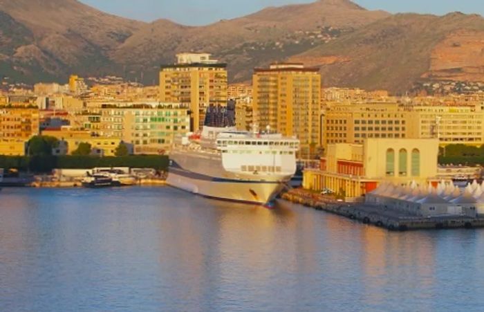 A ferry departing from the picturesque port city of Palermo.