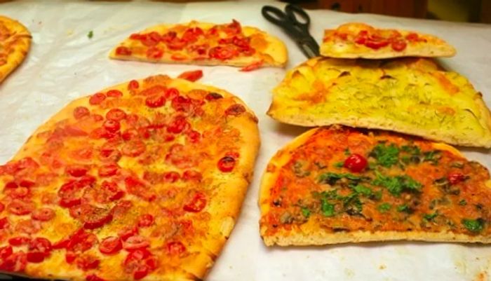 a slice of pizza being served at a pizzeria in Rome, Italy