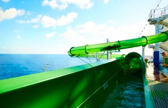 a woman sliding down a vibrant green waterslide