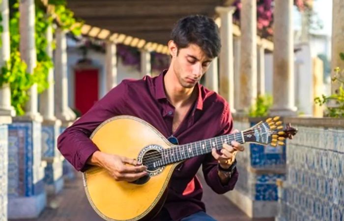 a Fado musician strumming a Portuguese guitar