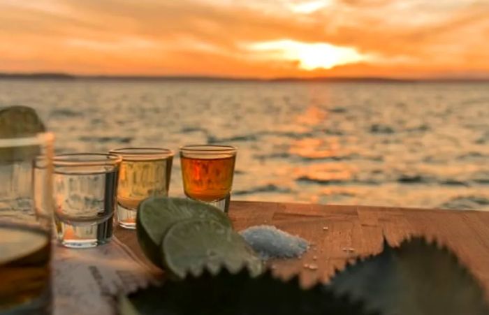 Mexican tequila served with salt and lime on the beach at sunset