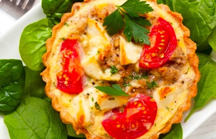 spinach and tuna tart topped with tomatoes and feta cheese