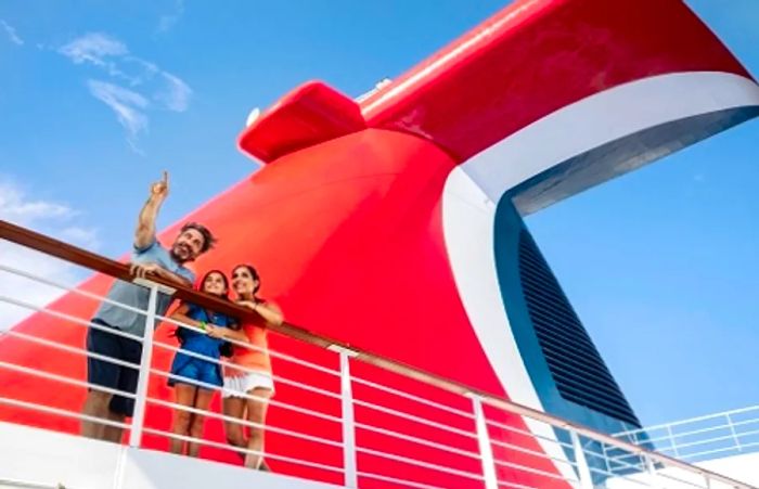 a family gathered on a dock next to the funnel of a Dinogo ship