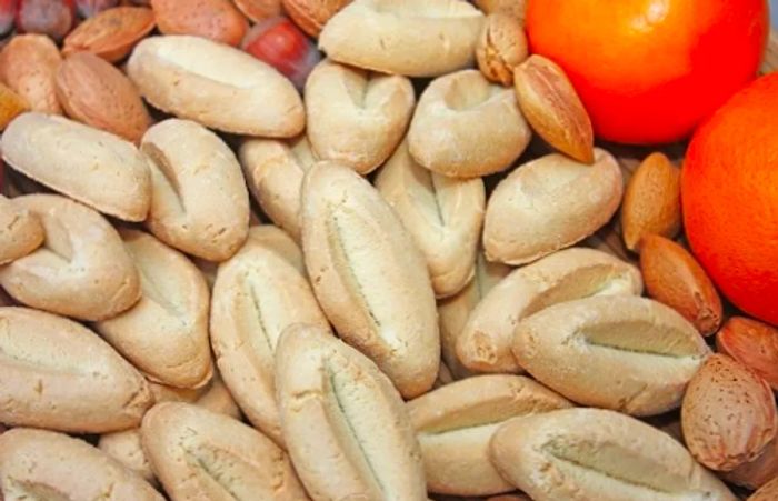 a display of navettes alongside oranges and walnuts at a vibrant marketplace