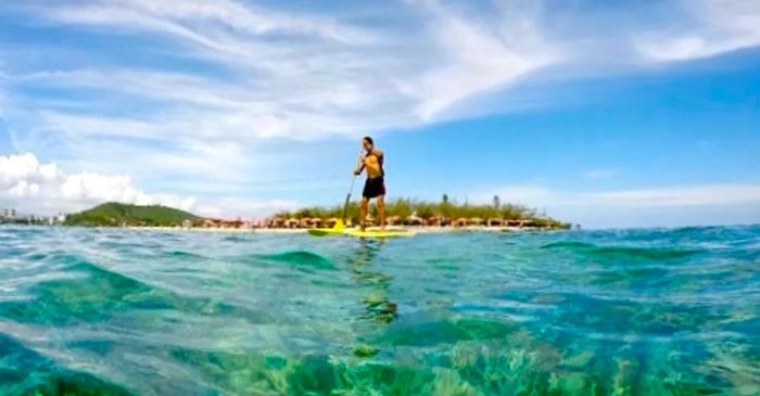 a man paddleboarding at Anse Vata Beach