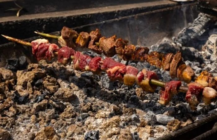 traditional espetada being prepared on a portuguese barbeque in madeira, portugal