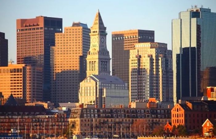 the sun illuminating the Boston city skyline