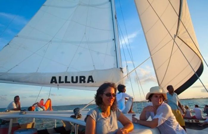 a group of people relishing the sunset aboard a catamaran