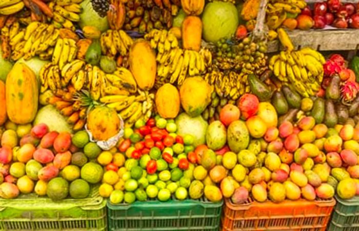 a selection of fresh fruits available in Dominica, including bananas, mangoes, and papayas