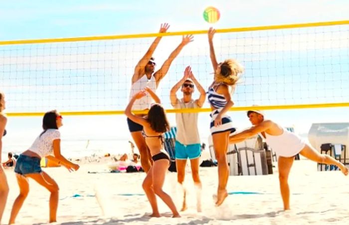 a group of friends enjoying a game of volleyball at a beach resort getaway in the Mexican Riviera