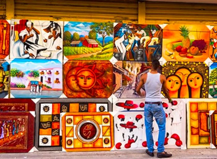 a man admiring local paintings available for sale on the street