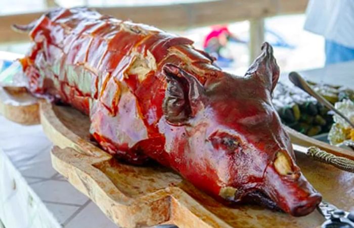 A whole roasted pig elegantly displayed on a table.