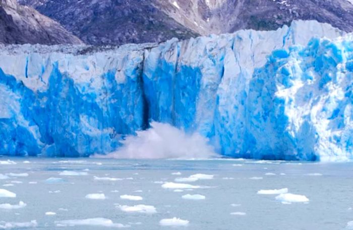 Ice calving from Sawyer Glacier and crashing into the ocean