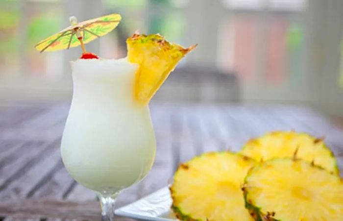 A piña colada served with fresh pineapple slices.