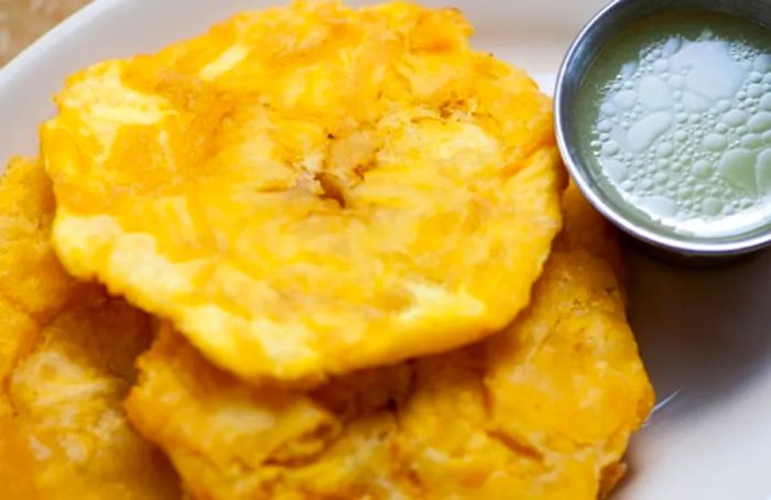 Tostones from La Romana, accompanied by a zesty green sauce.