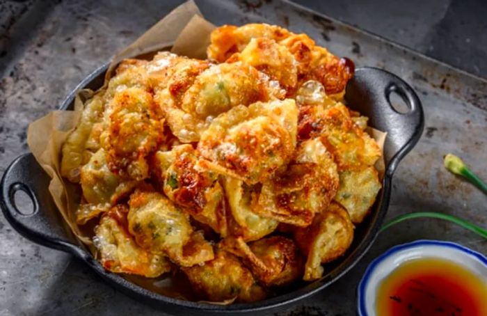 St. Maarten dumplings served in a black bowl with accompanying sauce