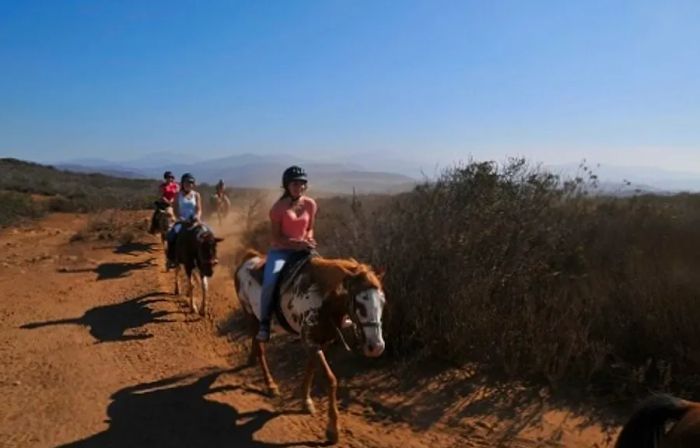 a woman riding horseback along a spectacular trail in Baja, Mexico