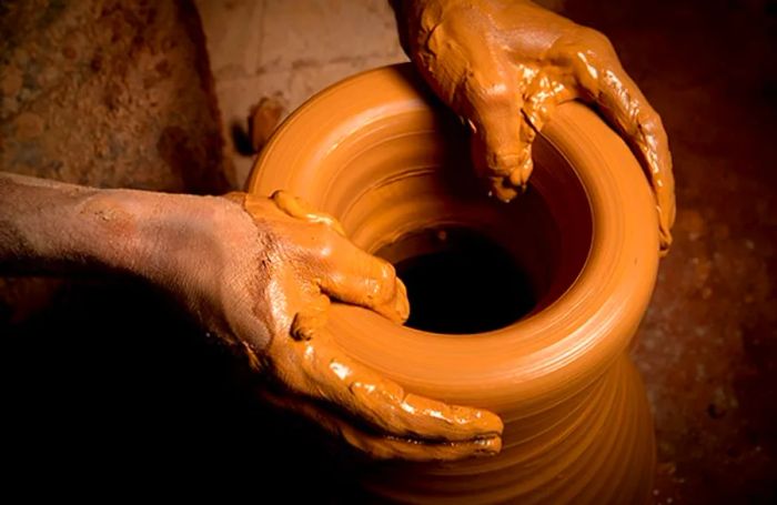 a potter shaping a large vase by hand