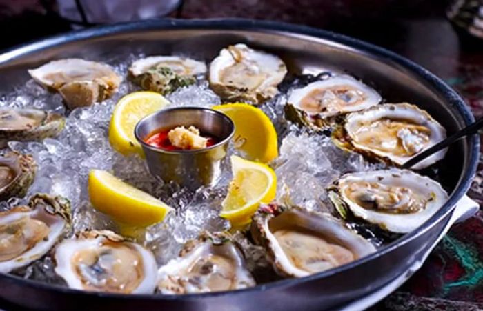 chilled Alaskan oysters presented on ice with lemon wedges