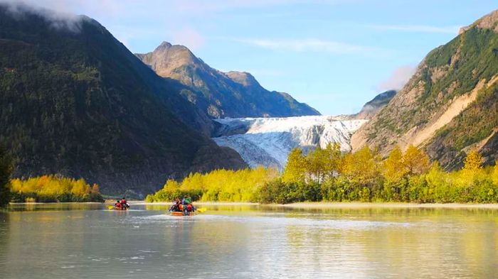 People kayaking in Skagway, Alaska, with mountains and glaciers in the background.