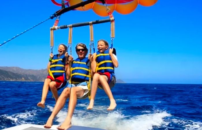 father and his two daughters enjoying a parasailing adventure in Baja Mexico