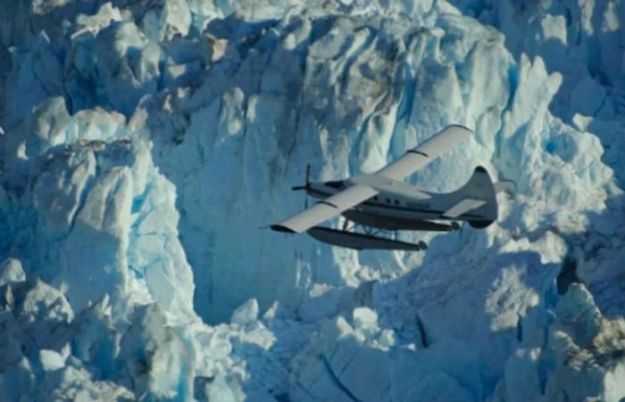 a seaplane flying close to a breathtaking glacier in Alaska