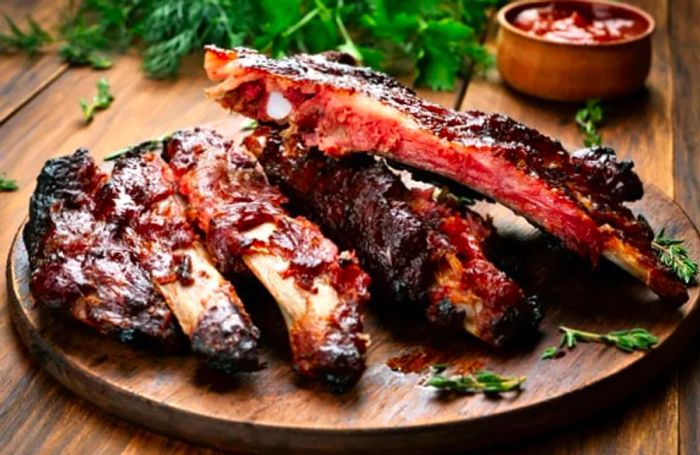 St. Maarten spare ribs served on a wooden platter with specialty barbecue sauce