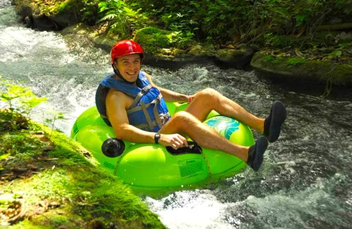 man joyfully tubing down the White River