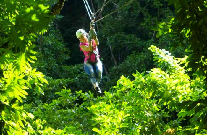 woman beams while zip lining over the White River Valley