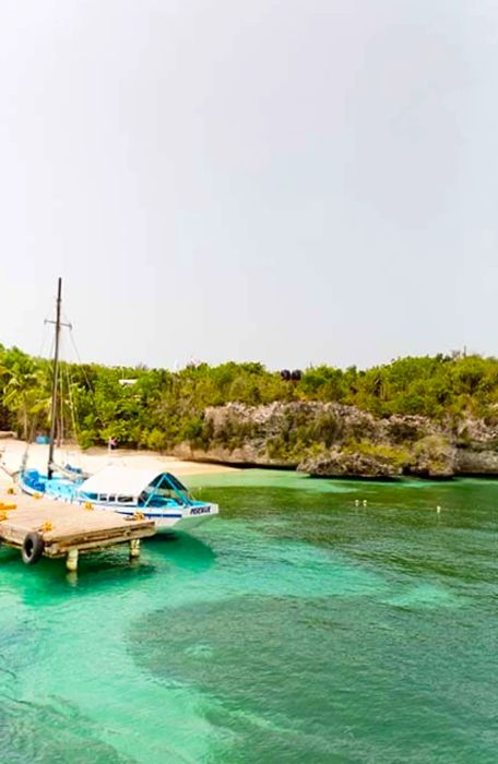 A perspective from the water showcasing a dock and beach on Catalina Island, Dominican Republic