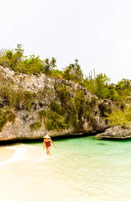 A woman strolling through the crystal-clear waters of Catalina Island, Dominican Republic