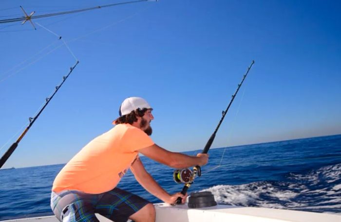 a man holding a fishing rod while bottom fishing off the coast of Freeport