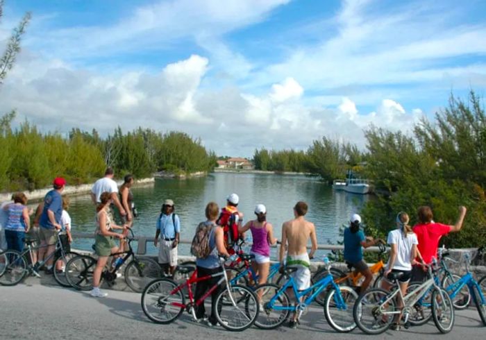 a group of people pausing on their bicycles in front of a river while a tour guide speaks in Freeport