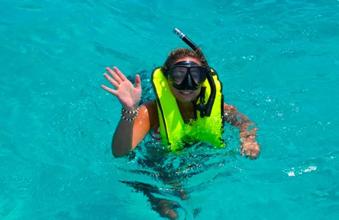 a woman joyfully snorkeling in the waters of Half Moon Cay