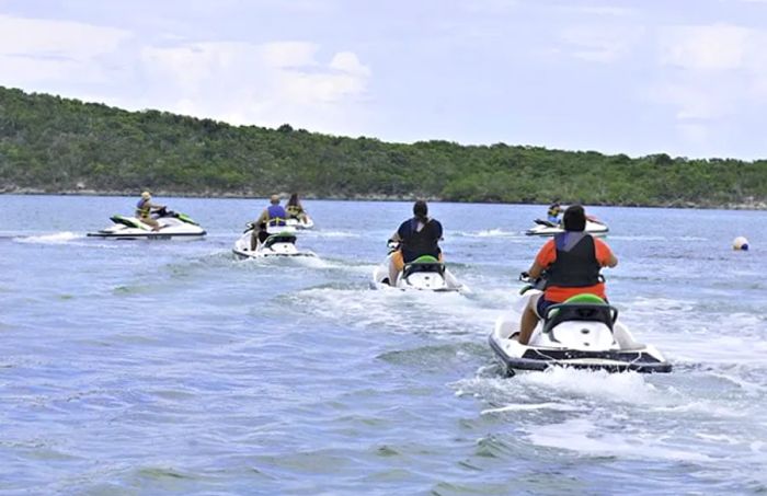 a group of individuals riding Aqua Trax watercrafts in Half Moon Cay