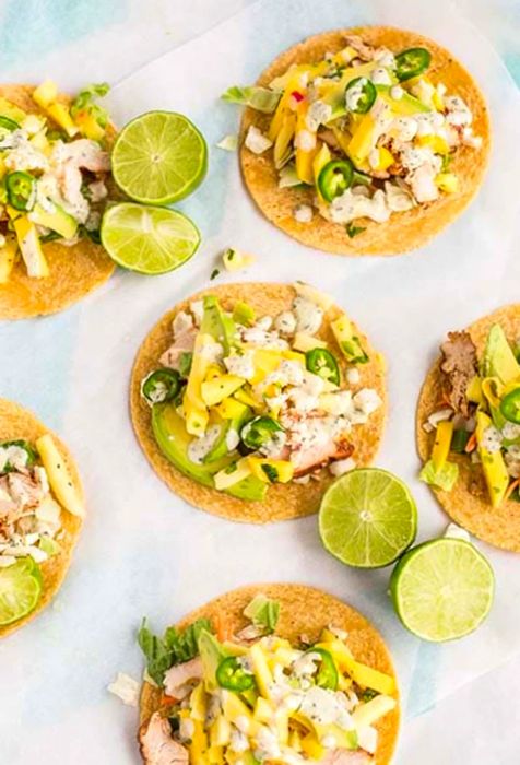 Overhead shot of pineapple mango chicken tacos with limes on the table