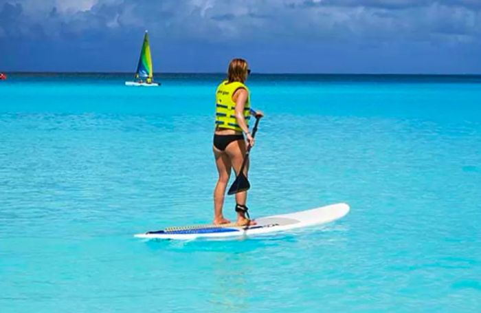 Sarah enjoying her time on a stand-up paddle board in the ocean at Half Moon Cay