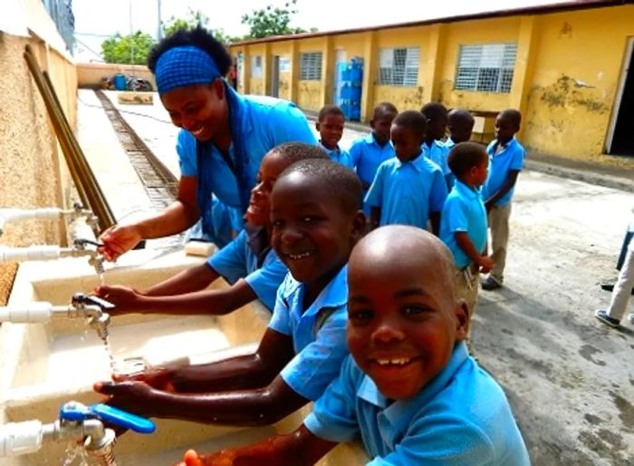 young boys washing their hands